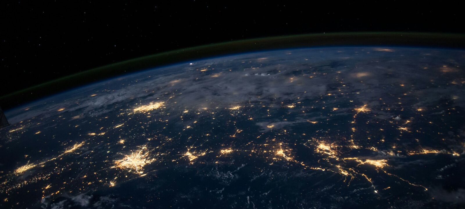Night-time satellite view of city lights connected across the globe